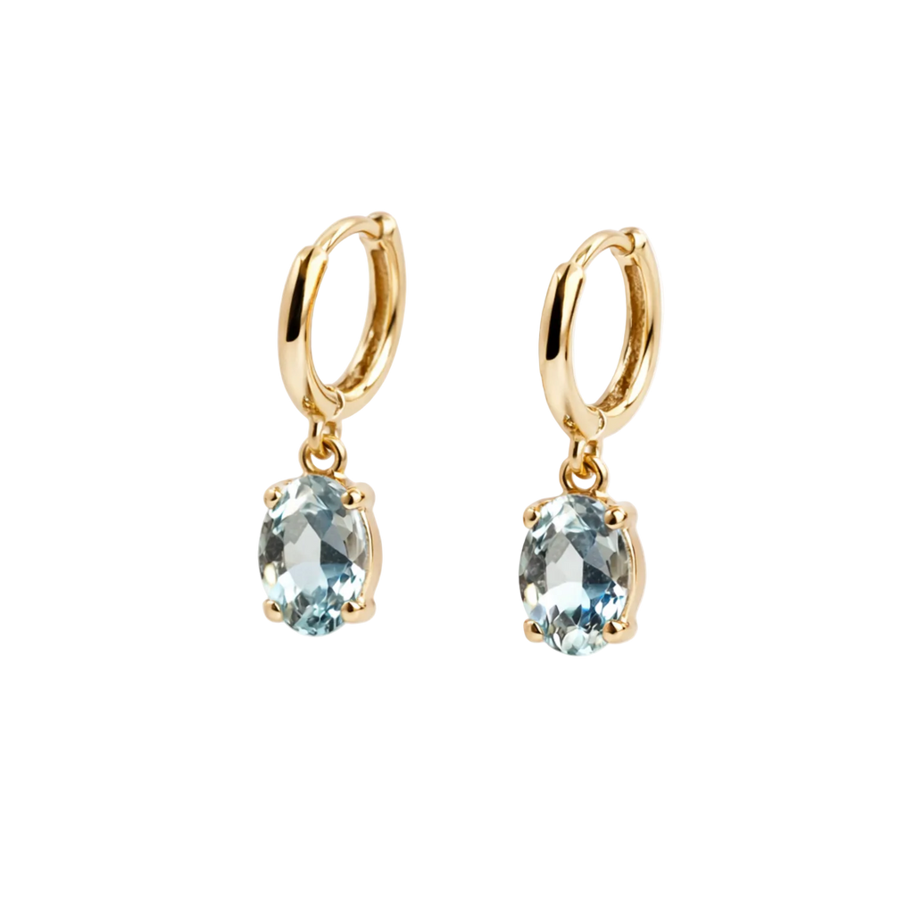 Gold earrings with blue gemstones on a white background