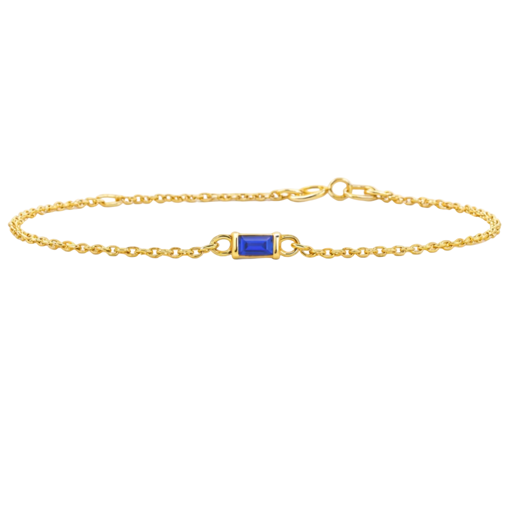 Gold bracelet with a blue gemstone on a white background