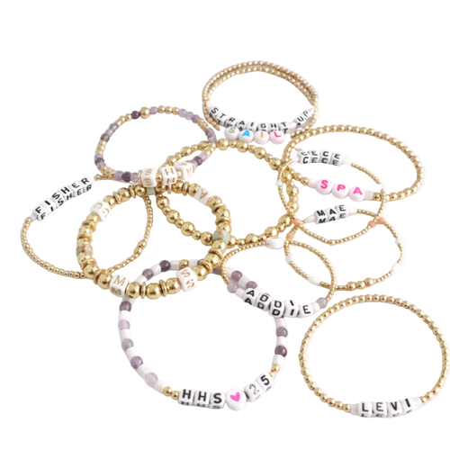 Set of personalized beaded bracelets with names on a white background