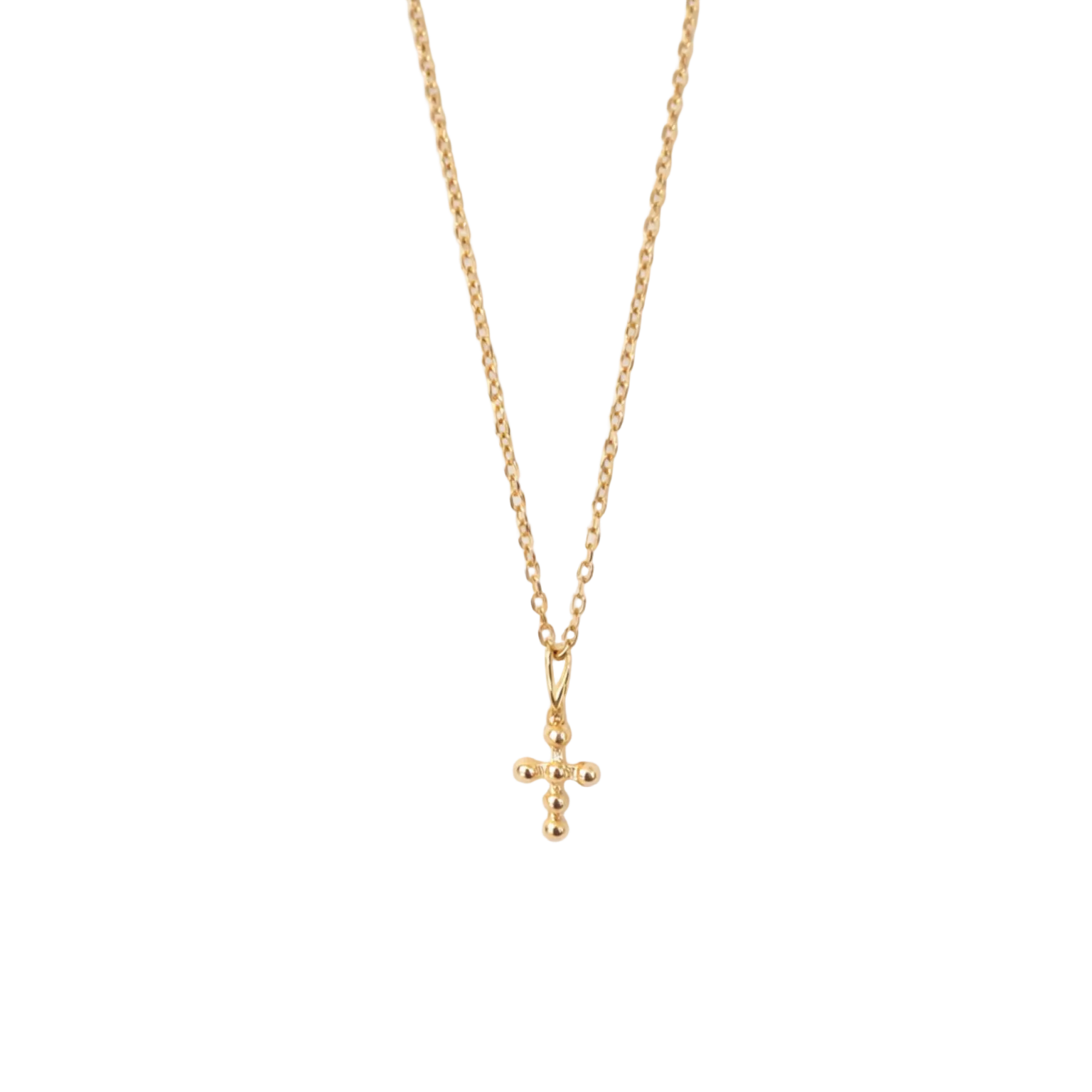 Gold necklace with a small cross pendant on a white textured background